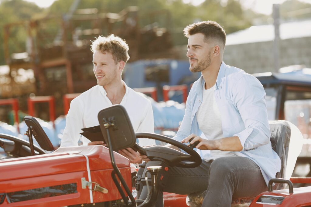 drain-cleaning Two men discussing sales while inspecting a tractor outdoors. Ideal for business and agriculture themes.